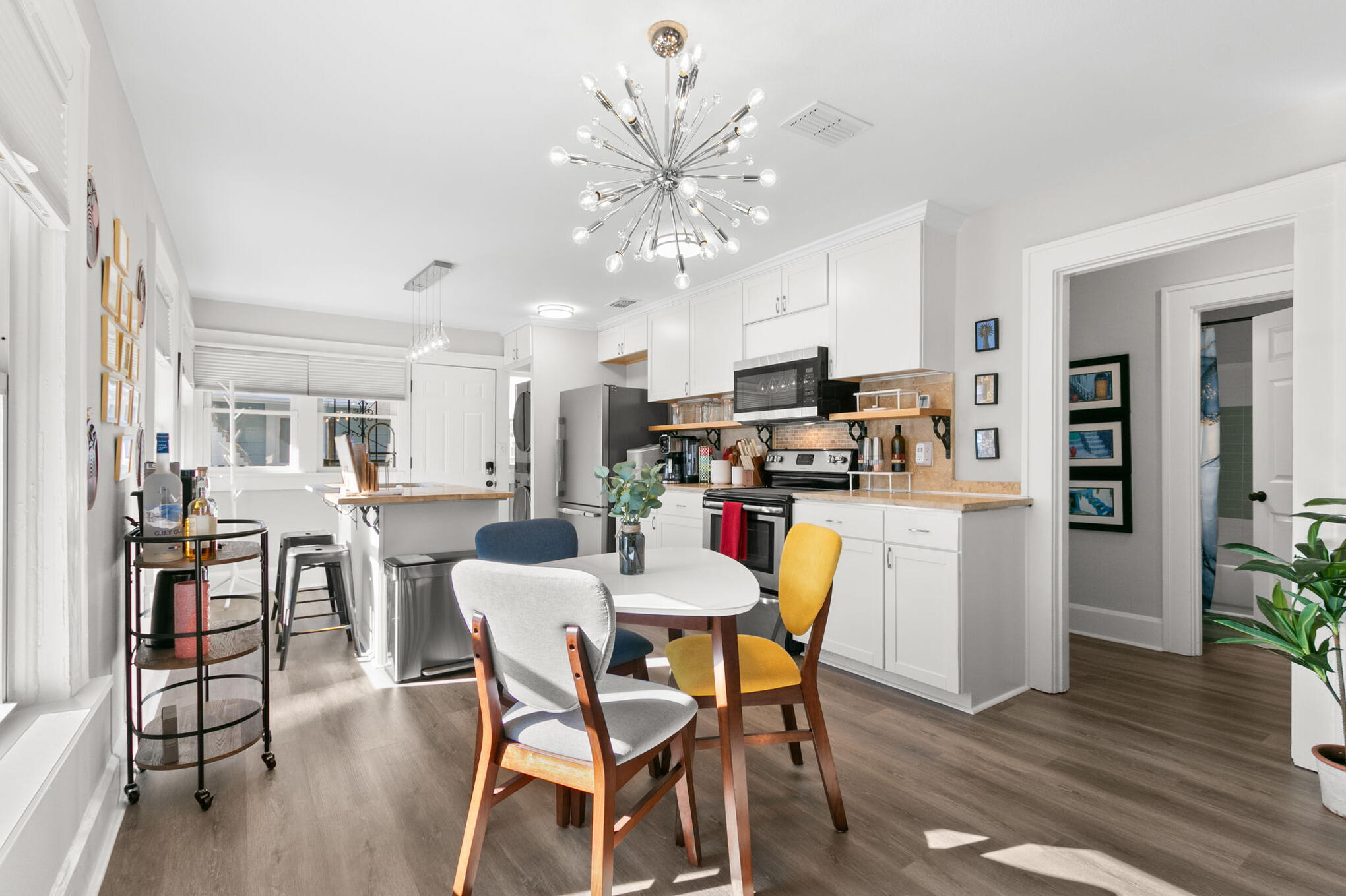 Bright Ella House kitchen and dining area with white cabinetry and colorful seating