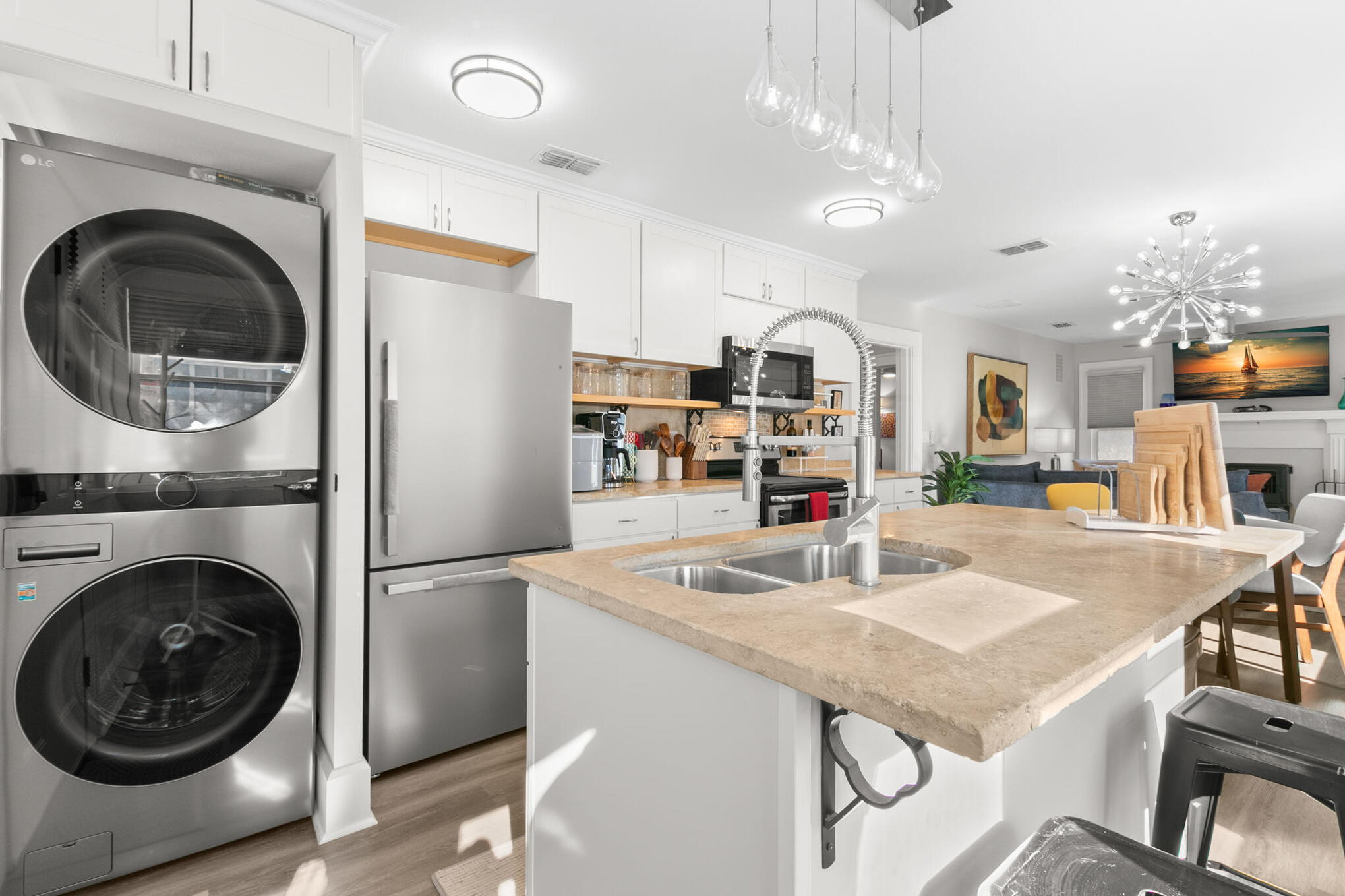 Ella House kitchen island beside the in-unit LG laundry and stainless-steel refrigerator